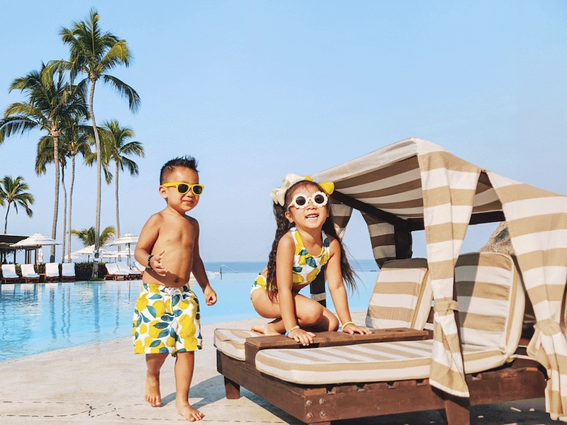 A boy and girl in swimsuits by a pool