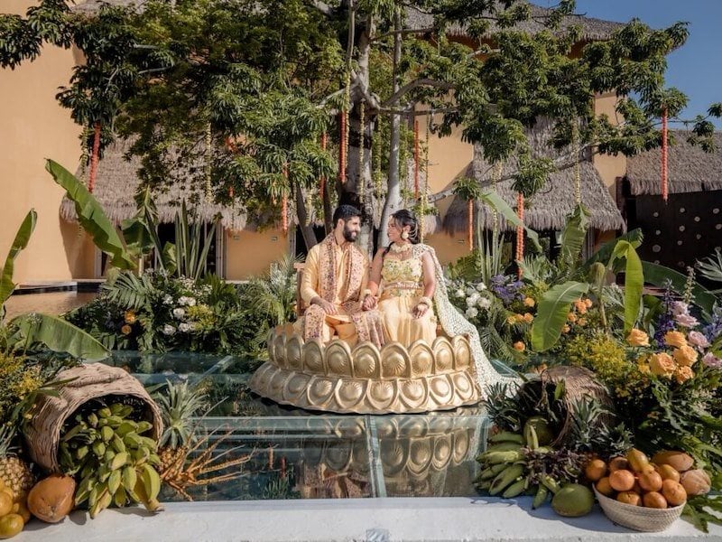 A man and woman sitting on a fountain in front of a house