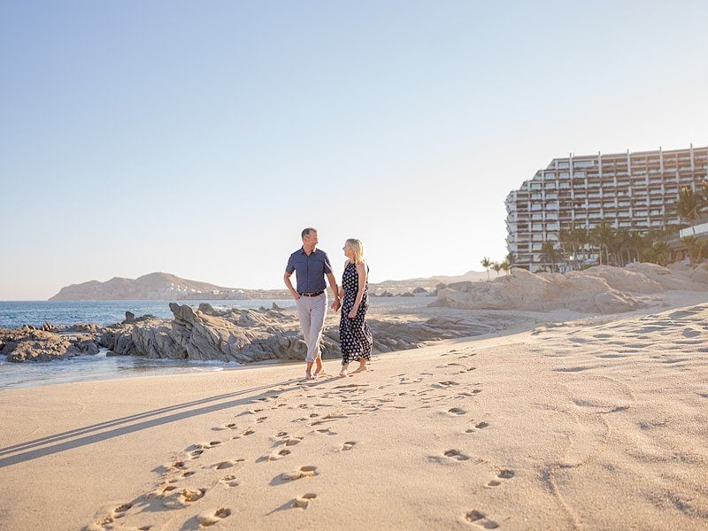 A man and woman walking on a beach